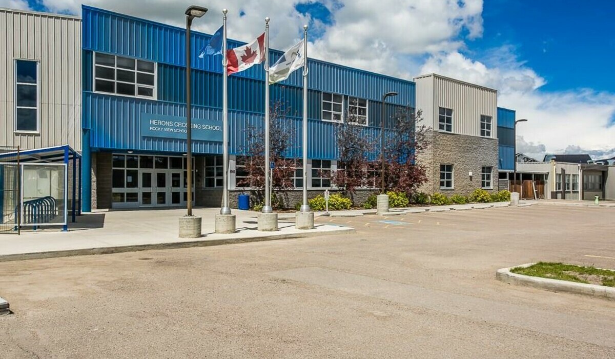 an image of the front of Herons Crossing School on a bright summer day